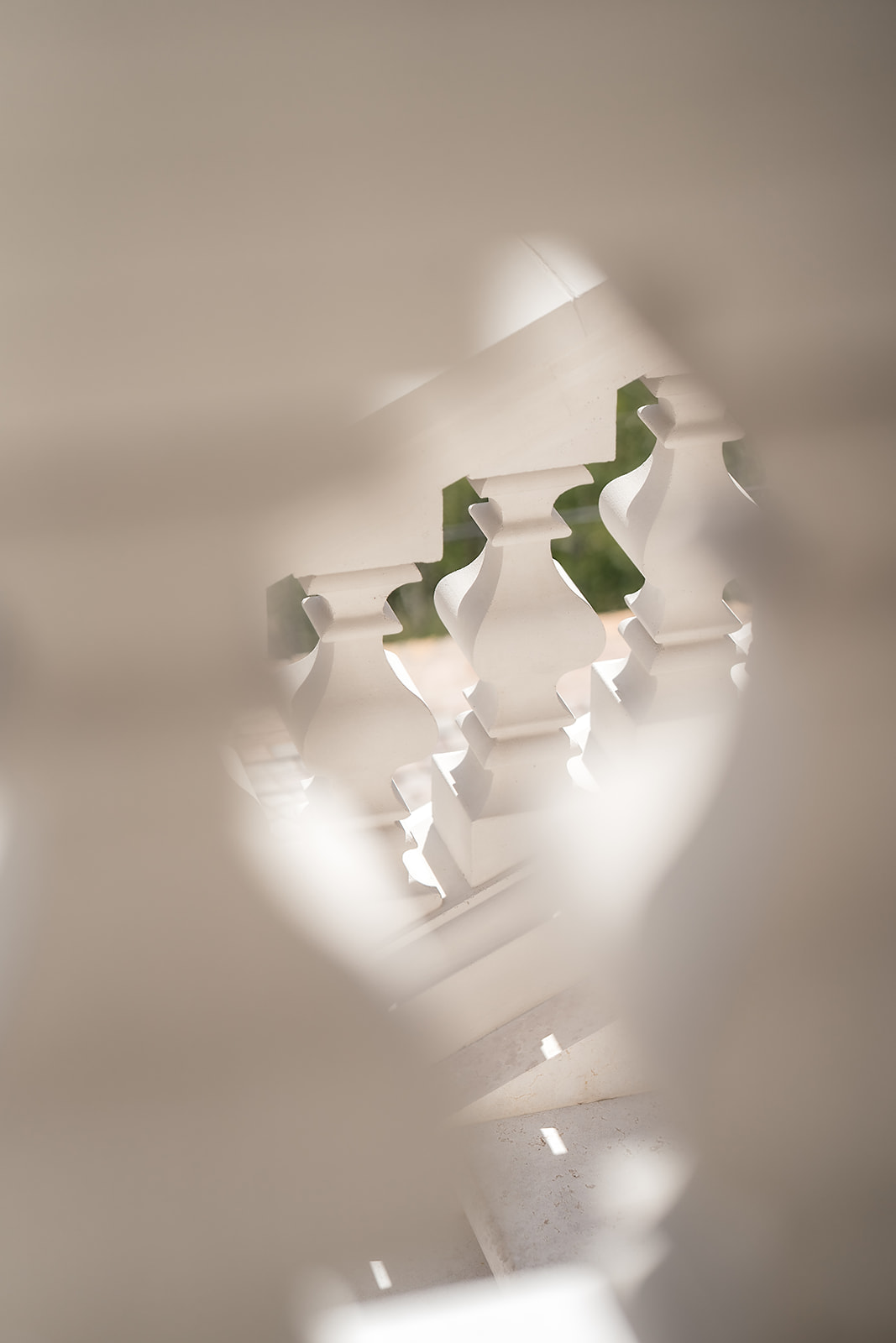A glimpse through balusters to the sunlit courtyard